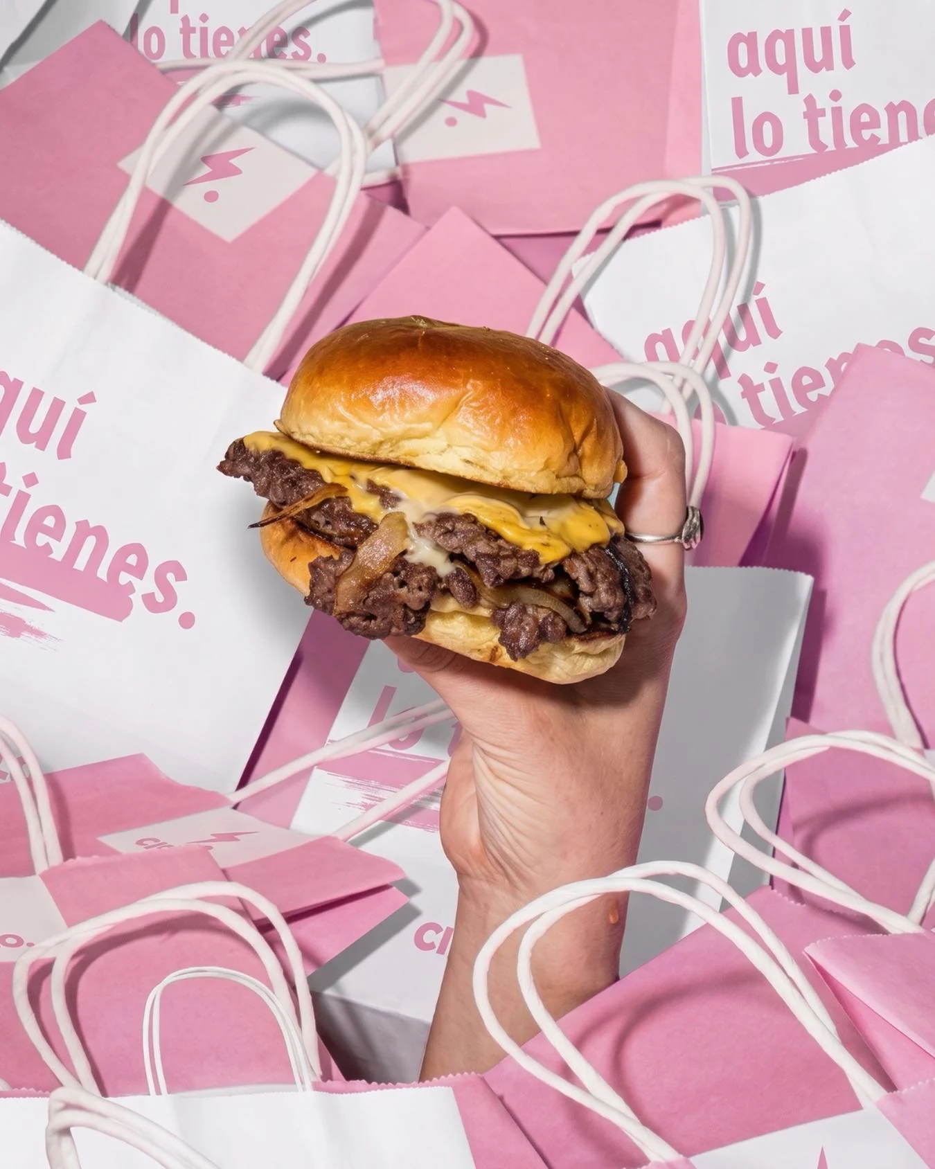 Smash burger de Cielo entre las bolsas rosas de la marca